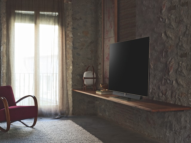 turned-off flat screen television on brown wooden TV stand