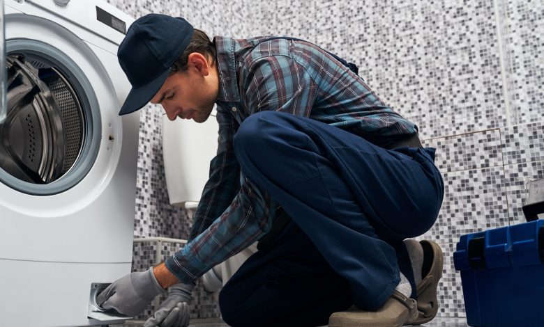 a plumber repairs a washing machine