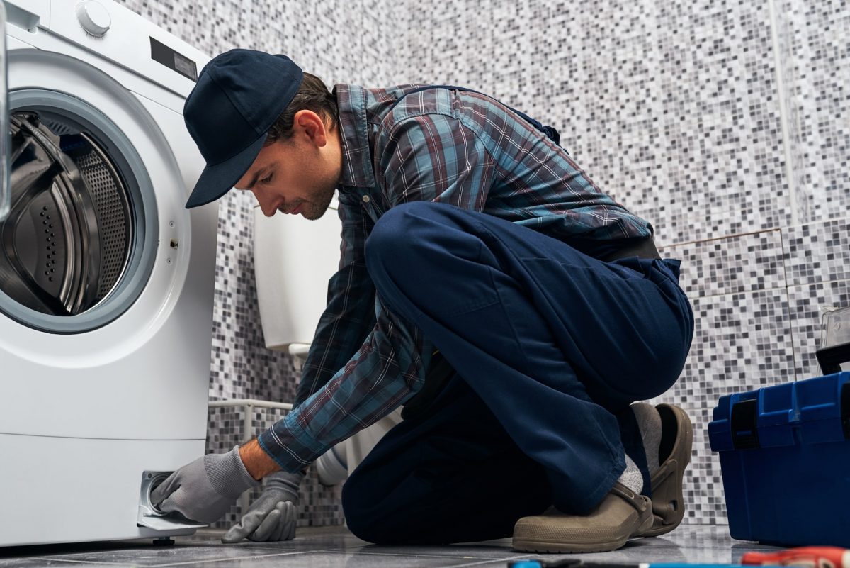 a plumber repairs a washing machine