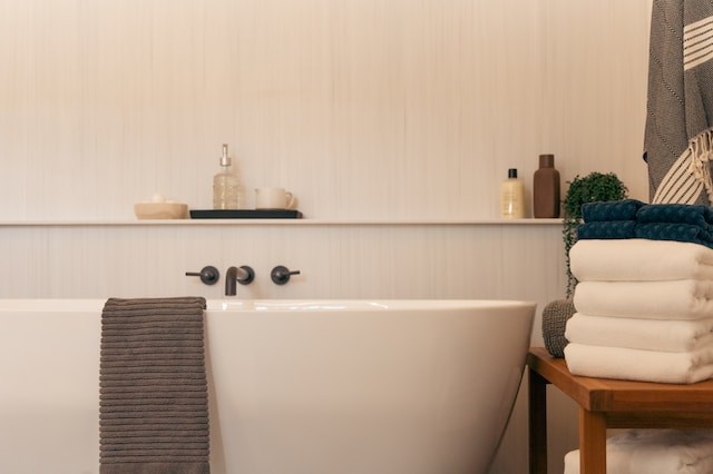 a white bath tub sitting next to a wooden tablewhite bath tub sitting next to a wooden table