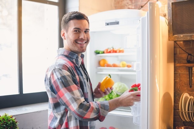 man put products in refrigerator