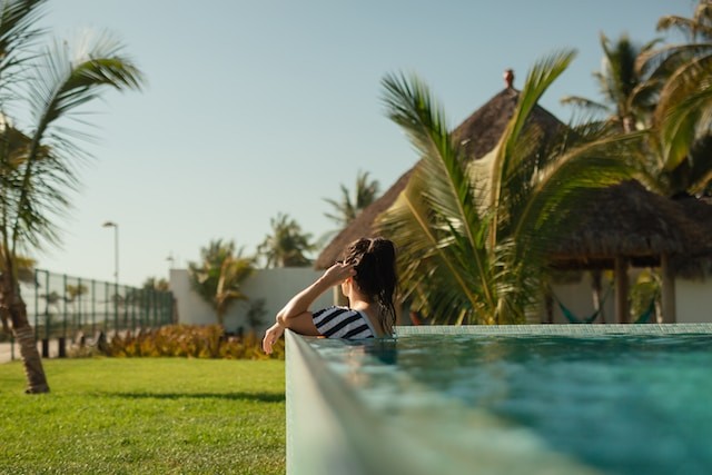 A woman sitting on the edge of a swimming pool