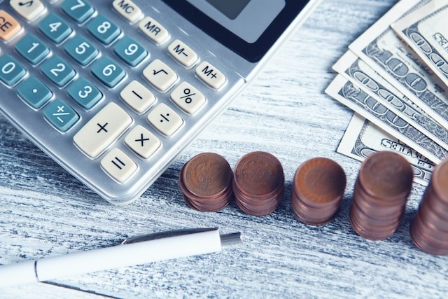 calculator, pen, and money on a table