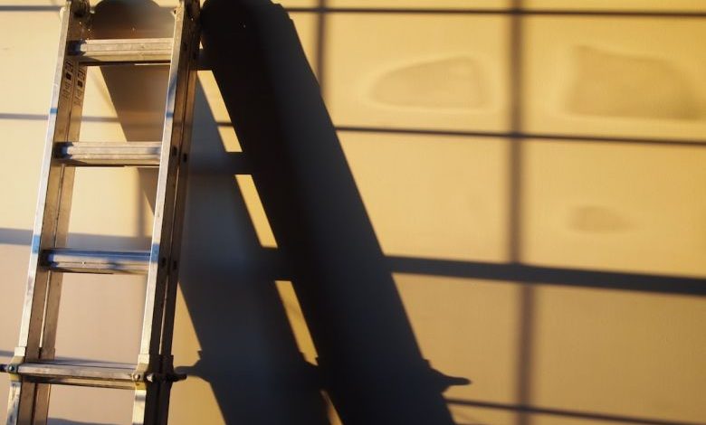 Ladder - black metal ladder leaning on white wall