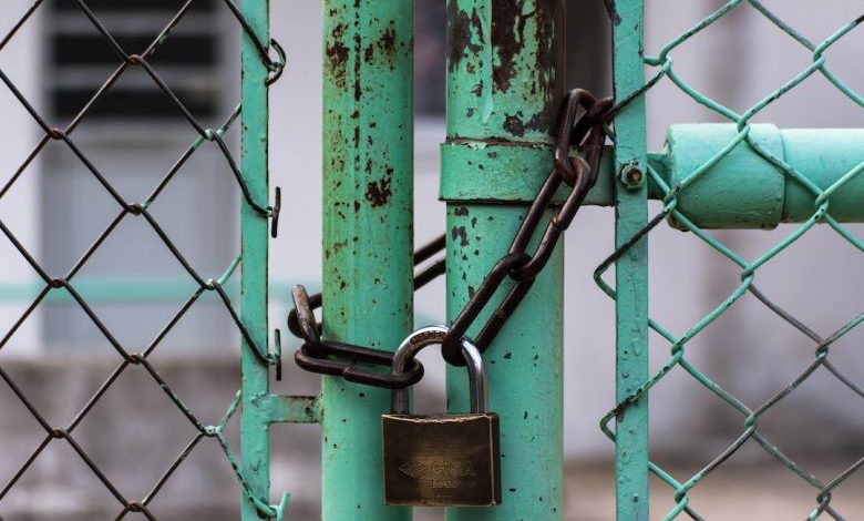Secure Fence - green metal gate with brown metal padlock