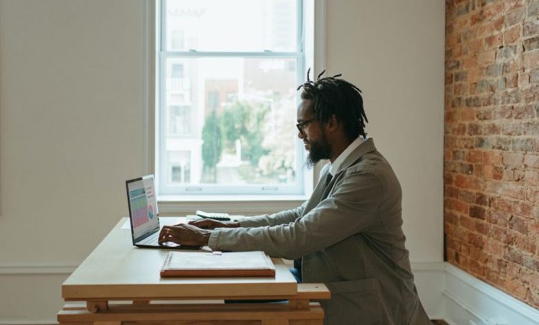 Home Office - a person sitting at a desk with a laptop and papers