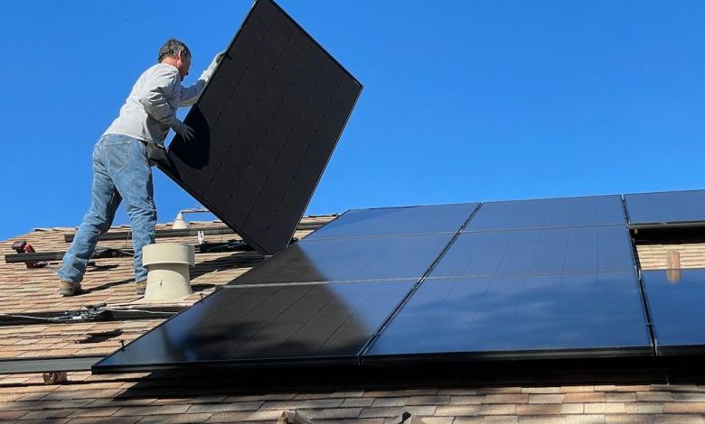 Solar Panels - man in white dress shirt and blue denim jeans sitting on white and black solar panel