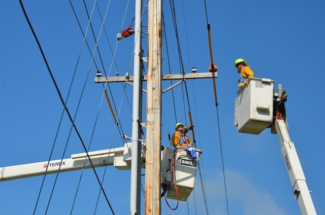 linemen with tools repairing lines