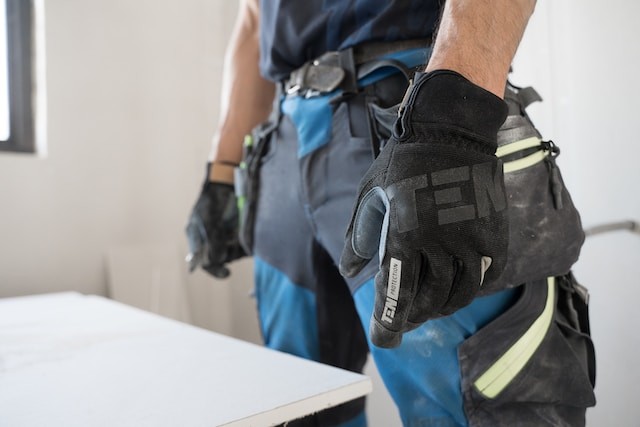 man wearing a pair of black and blue work gloves