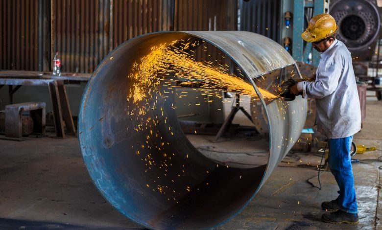 Metal Cutting Tool - man wearing yellow hard hat holding angle grinder