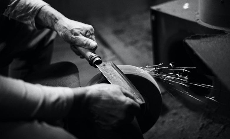 Tool Maintenance: Longevity Tips - person grinding cleaver