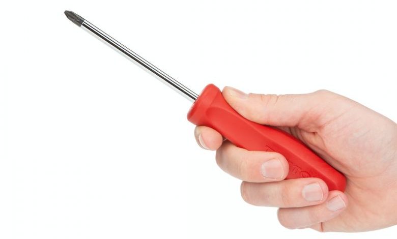 Screwdriver - person holding red and silver screw driver
