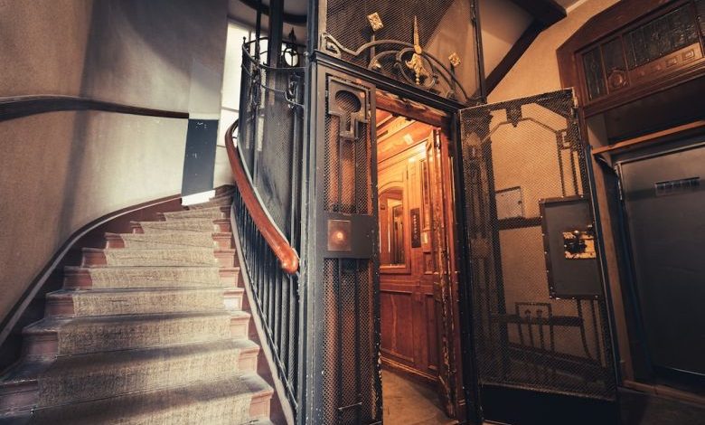Home Elevator - a staircase with a wrought iron door and railing