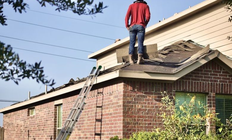 Roofing - a man standing on the roof of a house