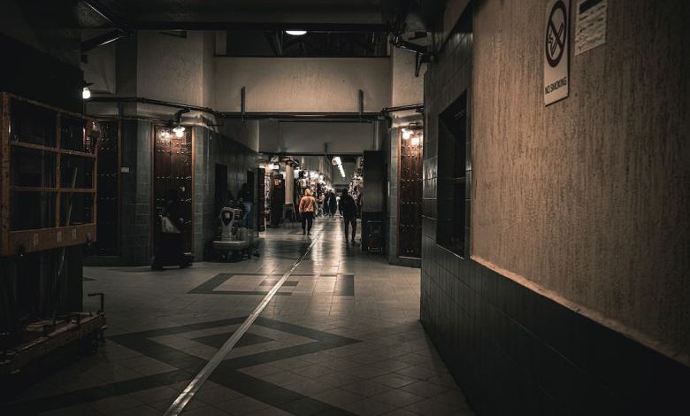 Best Flooring - a long hallway with a few people walking down it