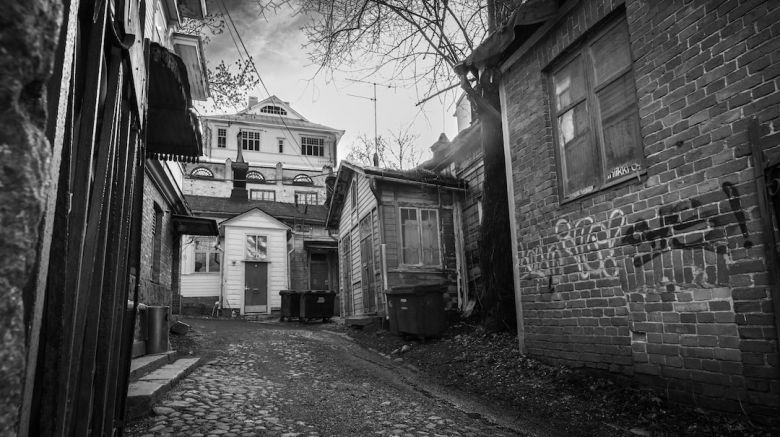 Garbage Cans - a black and white photo of an alley way