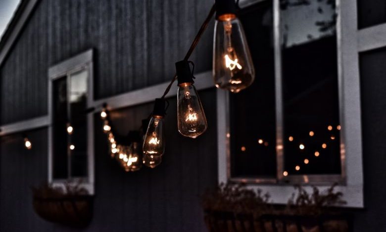 Outdoor Lighting - piled hanging lighted bulb beside house