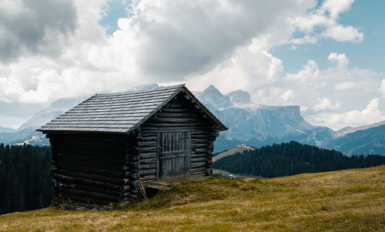 House Exteriors - wooden house on grass field on hill under cloudy sky at daytime