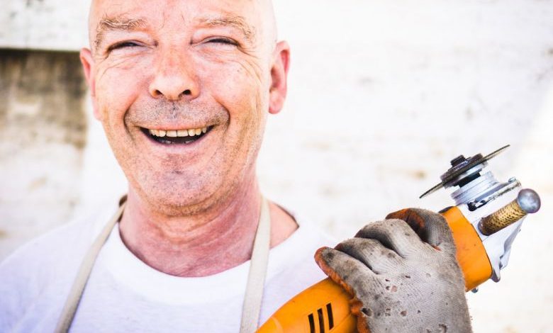 Essential Tool - man holding orange angle grinder