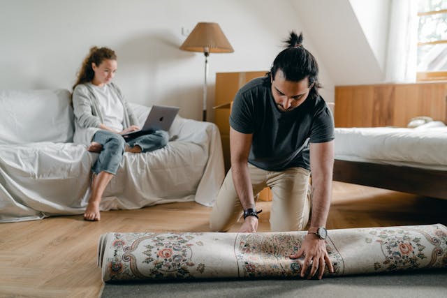 man-laying-rug-on-floor