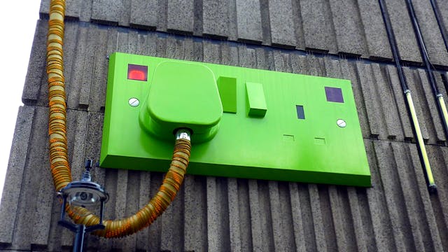 green-rectangular-corded-machine-on-grey-wall-during-daytime