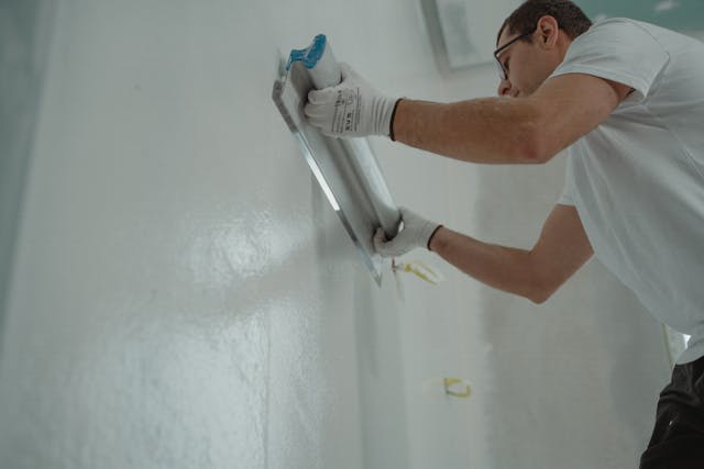 a-man-in-white-shirt-painting-a-house